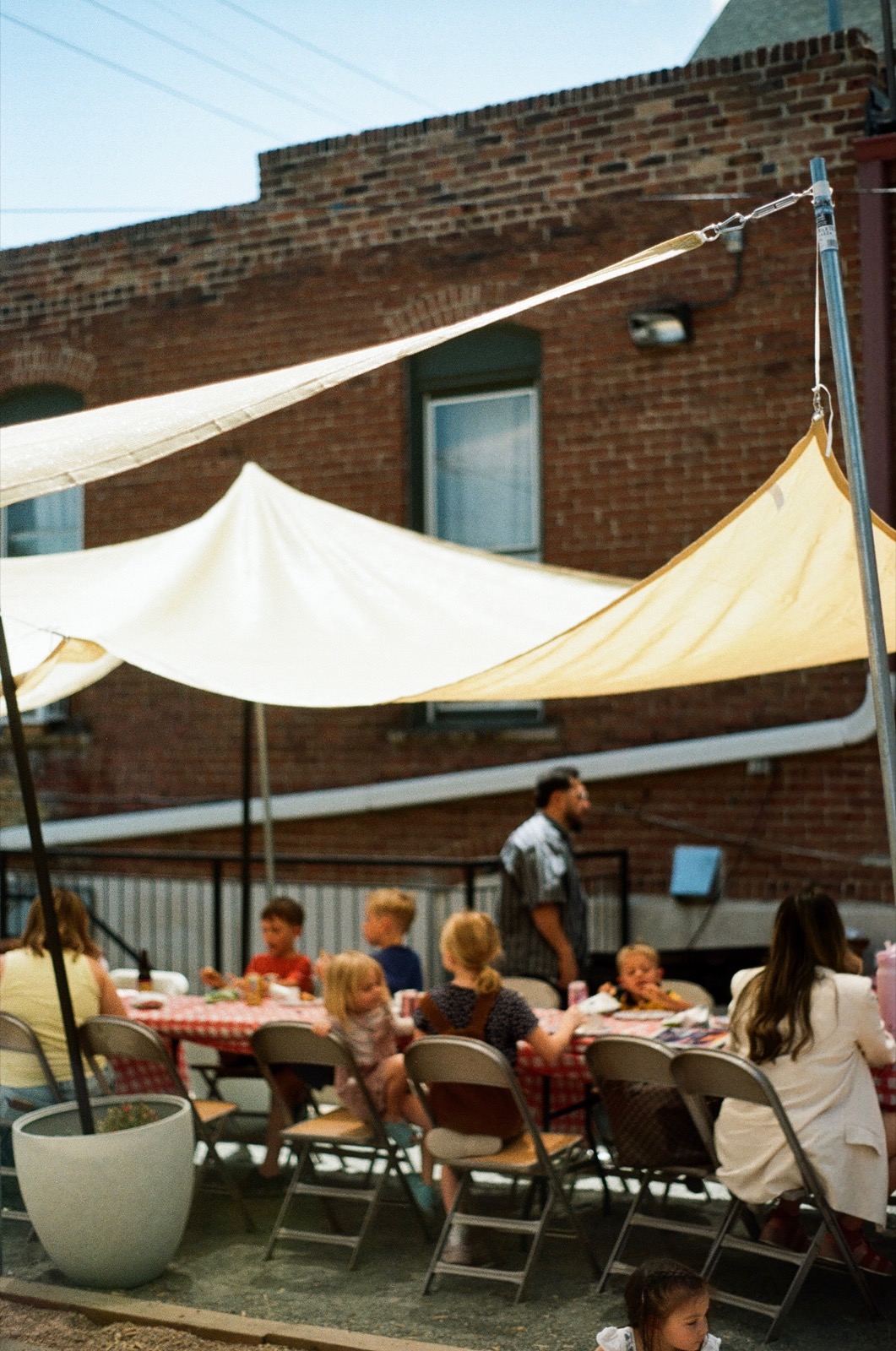 Anthem families gathering in the current backyard under shade sails